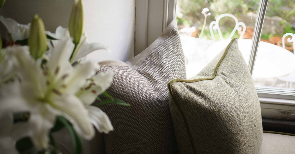 Luxury sofa cushions in neutral tones displayed in a window seat