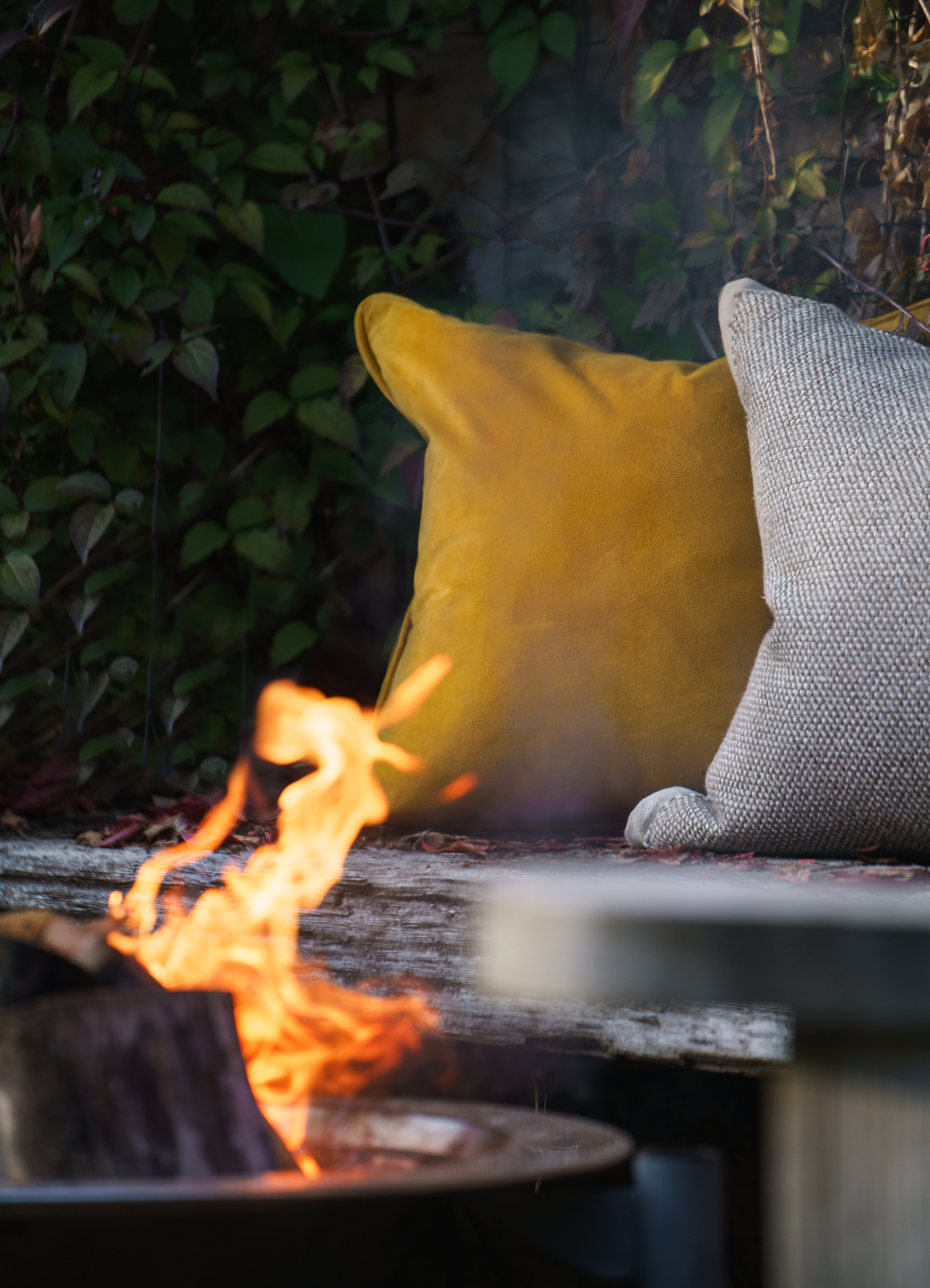 Luxury velvet cushion next to a fire in an autumn setting.