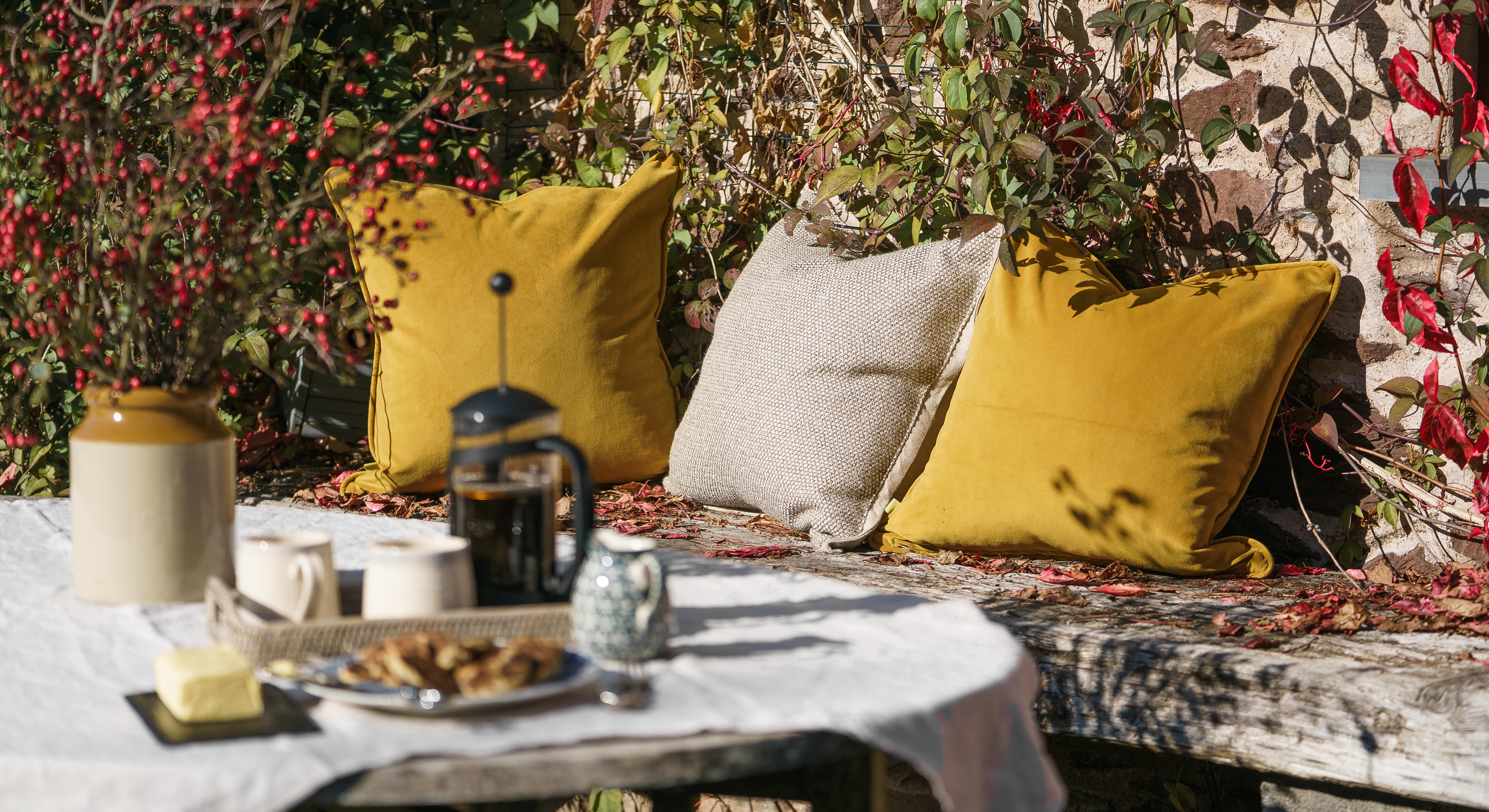 An Autumnal outdoor seating area upgraded with luxury cushions 