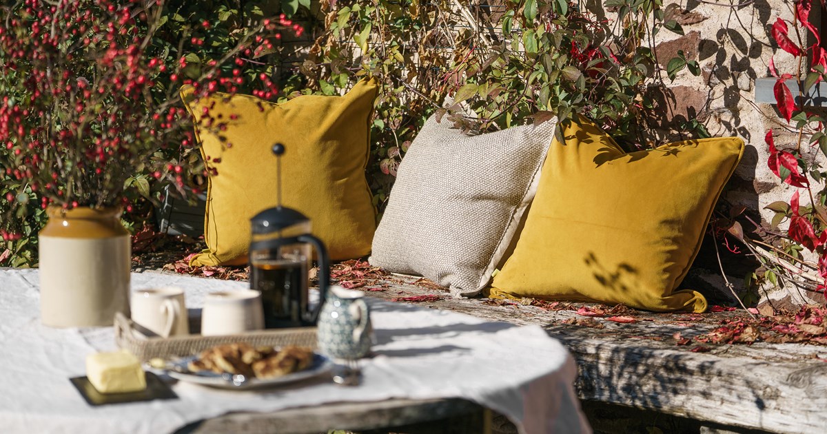 An Autumnal outdoor seating area upgraded with luxury cushions